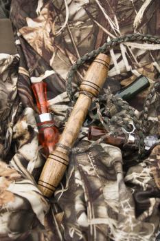 Royalty Free Photo of a Still Life Shot of Bird Calls Against Camouflage Clothing