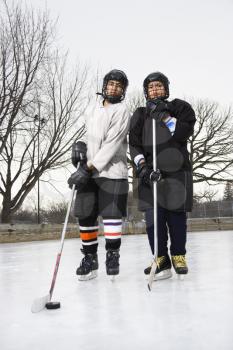 Royalty Free Photo of Two Ice Hockey Players in Uniform Standing on Ice