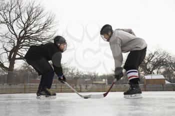 Royalty Free Photo of Two Ice Hockey Players in Uniform Facing off on Ice