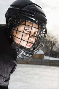 Royalty Free Photo of a Hockey Player Boy in a Cage Helmet With a Look of Concentration