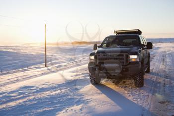 Royalty Free Photo of a Truck on an Ice Covered Road and Snowy Rural Landscape