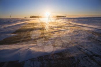 Royalty Free Photo of an Ice Covered Road With Sun Rising in the Distance