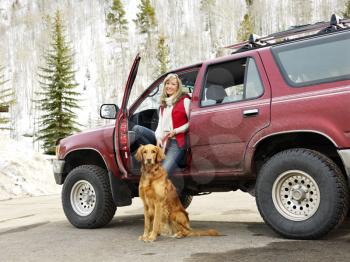 Royalty Free Photo of a Woman Sitting in an SUV With Her Dog