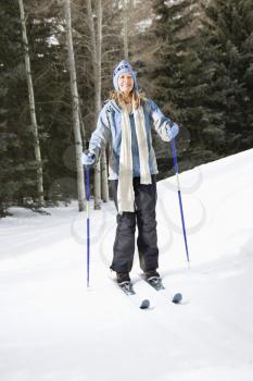 Royalty Free Photo of a Female Skier Wearing Blue Ski Clothing Smiling