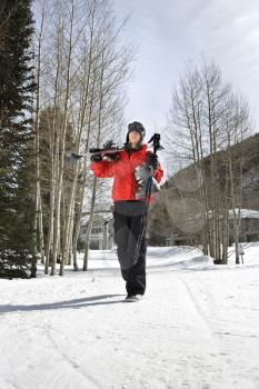 Royalty Free Photo of Teenager Walking and Carrying Ski Gear