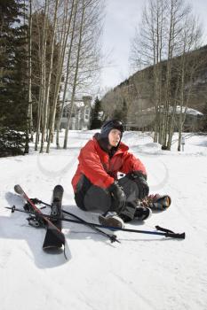 Royalty Free Photo of a Teenager Sitting With Skis