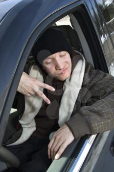 Royalty Free Photo of a Teenager Making a Hand Gesture While Sitting in a Car