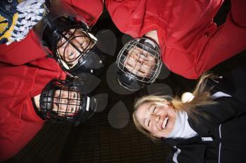 Royalty Free Photo of Female Hockey Players in a Huddle With Their Coach
