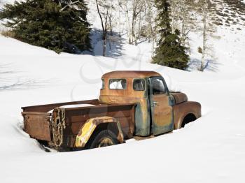 Royalty Free Photo of an Old Rusted Classic Truck in a Snow Covered Field