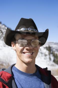 Royalty Free Photo of Young Cowboy Wearing Sunglasses and Cowboy Hat in Winter