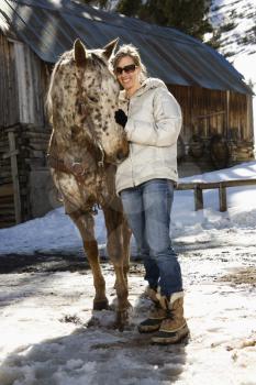 Royalty Free Photo of a Woman Petting a Horse
