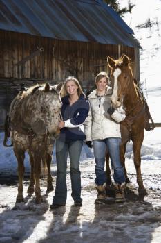 Royalty Free Photo of Two Women Standing With Horses