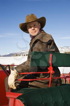 Mid-adult Caucasian man in sleigh looking at viewer. 