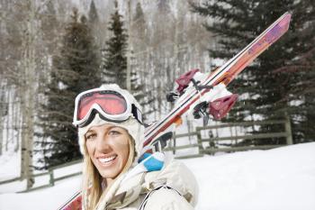 Royalty Free Photo of a Female Skier Carrying Skis on Her Shoulder