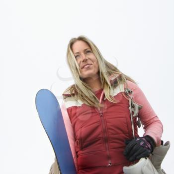 Royalty Free Photo of a Woman Holding a Snowboard and Boots
