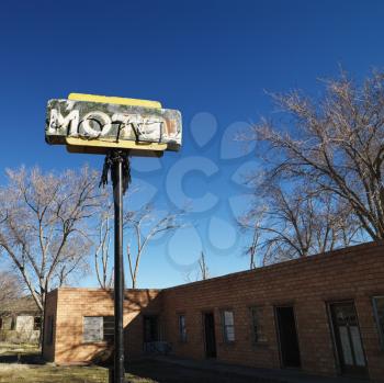 Royalty Free Photo of a Rundown Motel Building With a Blue Sky in the Background