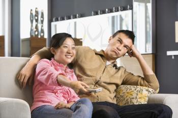 Royalty Free Photo of  a Couple Sitting on a Couch watching TV