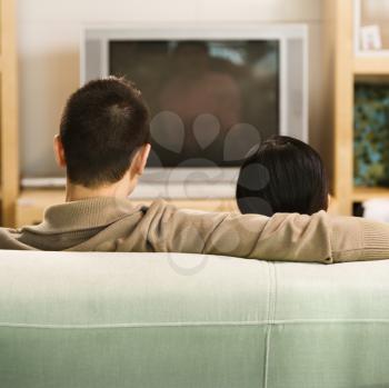 Royalty Free Photo of a Couple Sitting on a Couch Watching TV