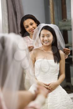 Royalty Free Photo of a Bride and Her Friend Admiring the Dress in the Mirror