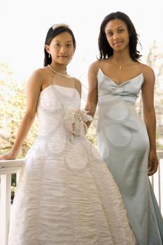 Royalty Free Photo of a Bride and the Maid of Honor Leaning Against a Railing