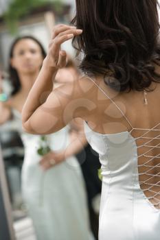 Royalty Free Photo of a Back of an African-American Woman in an Evening Gown Looking in a Mirror