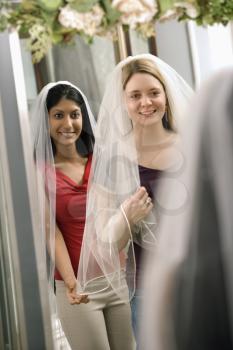 Royalty Free Photo of Women Trying on Veils and Looking in the Mirror