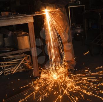 Royalty Free Photo of a Metal Smith Shaping Metal and Creating Sparks