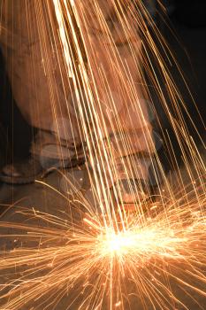 Royalty Free Photo of a male Metal Smith Shaping Metal and Creating Sparks