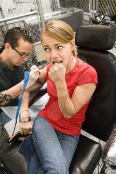 Royalty Free Photo of a Tattoo Artist Tattooing a Woman