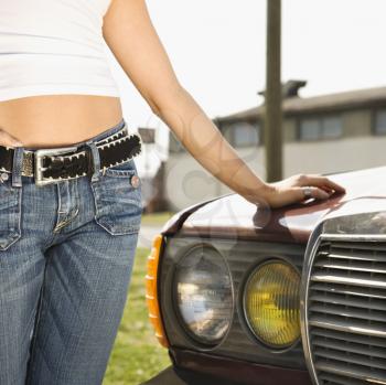 Royalty Free Photo of a Woman Standing Beside an Automobile