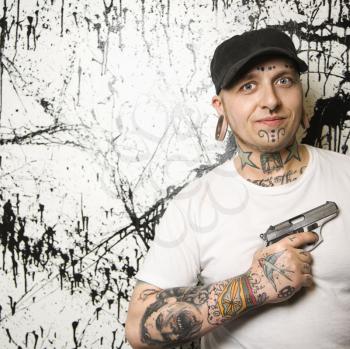 Royalty Free Photo of a Tattooed Man Holding a Gun