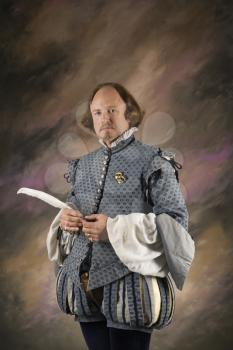 Royalty Free Photo of William Shakespeare in Period Clothing Holding a Feather Pen 
