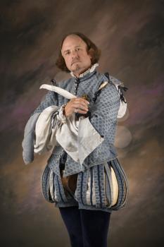 Royalty Free Photo of William Shakespeare in Period Clothing Holding a Feather Pen 