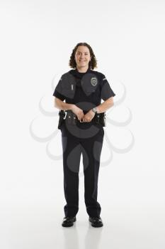Royalty Free Photo of a Policewoman Standing With Hand on Gun Holster and Smiling