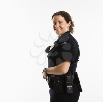 Royalty Free Photo of a Policewoman Standing With Hand on Gun Holster Smiling