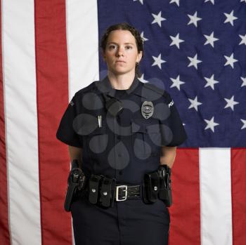 Royalty Free Photo of a Policewoman Standing Before an American Flag Backdrop