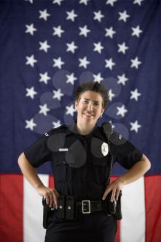 Royalty Free Photo of a Policewoman Standing in Front of an American Flag
