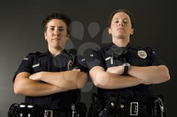 Royalty Free Photo of a Portrait of Two Policewomen standing with their arms crossed