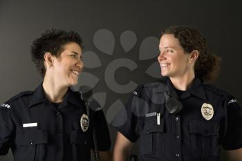 Royalty Free Photo of Policewomen Standing Smiling at Each Other