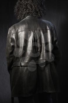Royalty Free Photo of the Back View of a Woman With Curly Hair Wearing a Black Leather Jacket