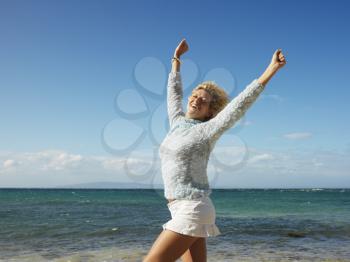 Royalty Free Photo of an Attractive Blond Woman Smiling With Arms Raised in the Air on Maui, Hawaii Beach