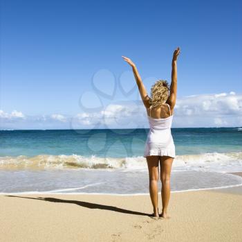 Royalty Free Photo of a Woman Smiling With Her Arms Raised in the Air on Maui, Hawaii Beach