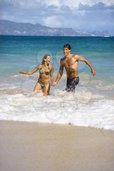 Royalty Free Photo of a Couple Running and Smiling in Water in Maui, Hawaii