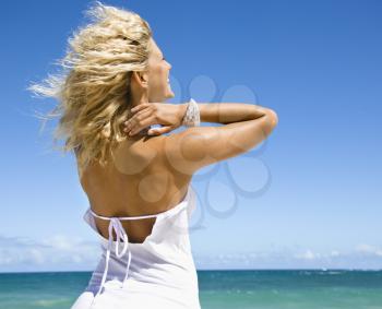 Royalty Free Photo of a Blond Woman Standing on a Maui, Hawaii Beach Looking Out at The Ocean