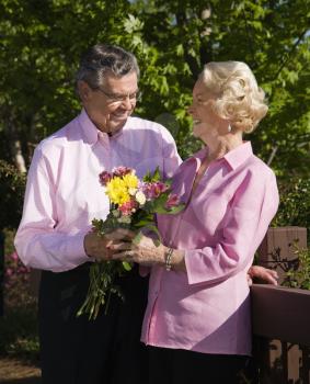 Royalty Free Photo of an Older Man Giving a Woman Flowers