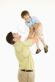 Royalty Free Photo of a Father Holding Up a Boy Overhead