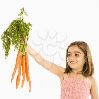 Royalty Free Photo of a Smiling Girl Holding a Bunch of Carrots
