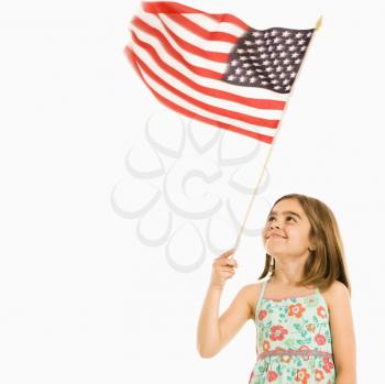 Girl holding American flag against white background.