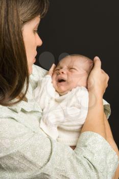 Royalty Free Photo of a Mother Smiling While Holding Her Baby 