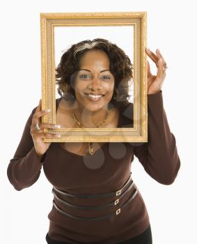 Royalty Free Photo of a Woman Holding an Empty Frame Around Her Head Smiling